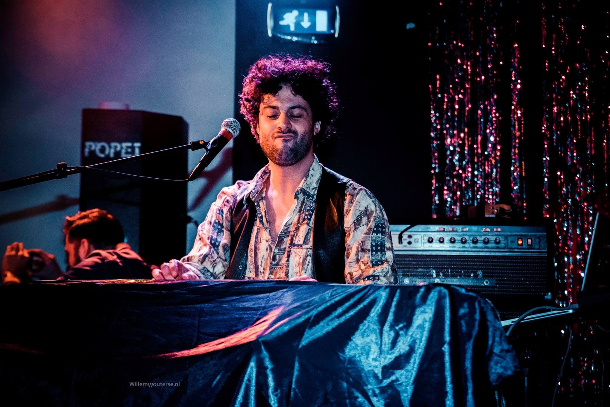 Osman Meyredi playing keyboards on stage in Eindhoven